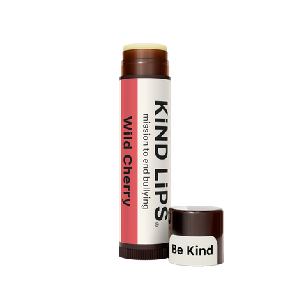 Lip balm tube and cap in brown with pale yellow base; standing side view.