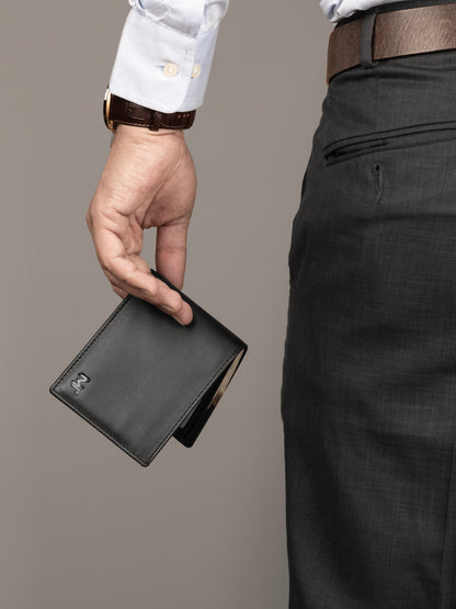 Black bi-fold wallet held by a person, front panel visible with MT logo