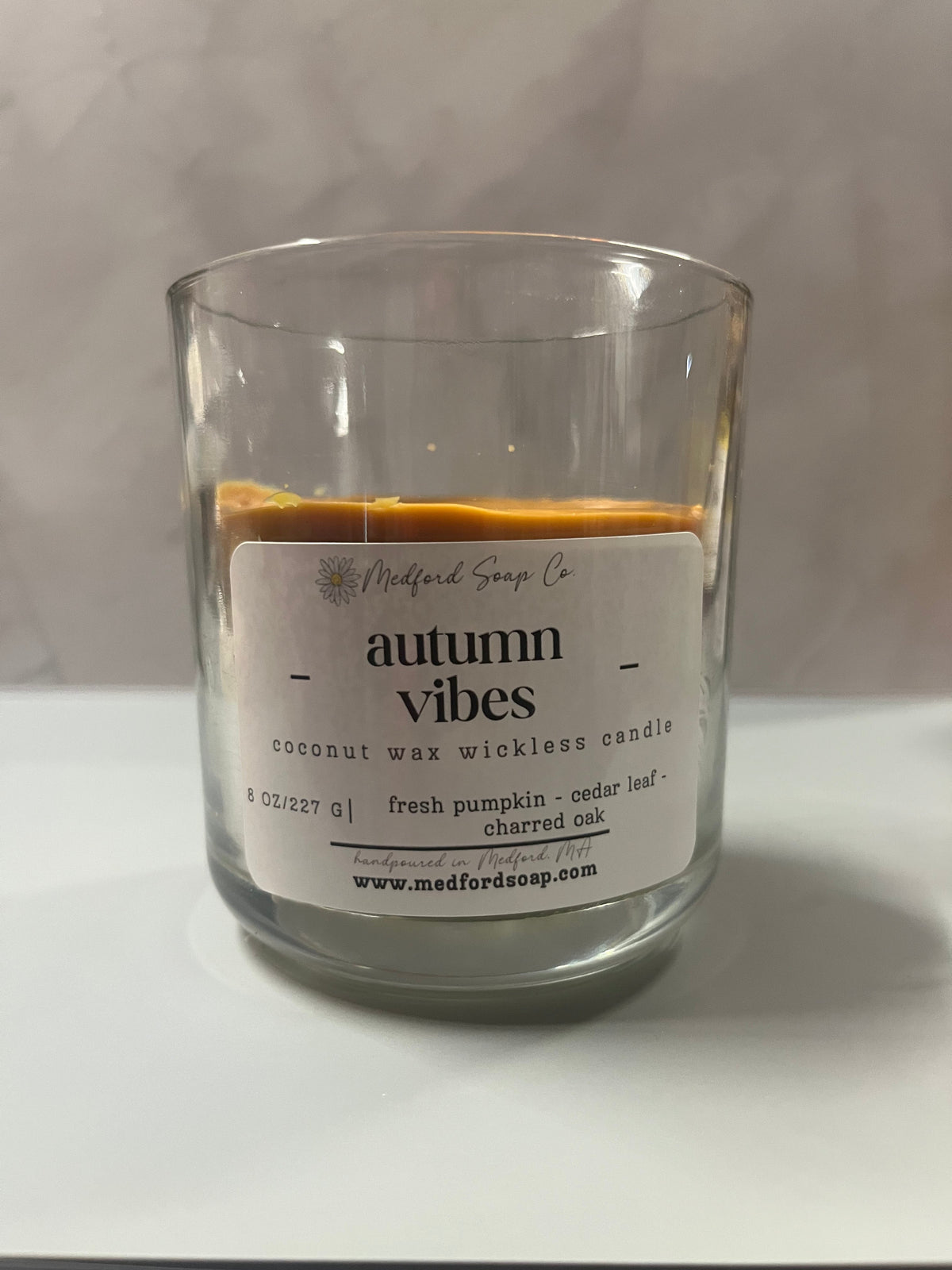Wickless candle in a clear glass jar with autumn vibes wax label
