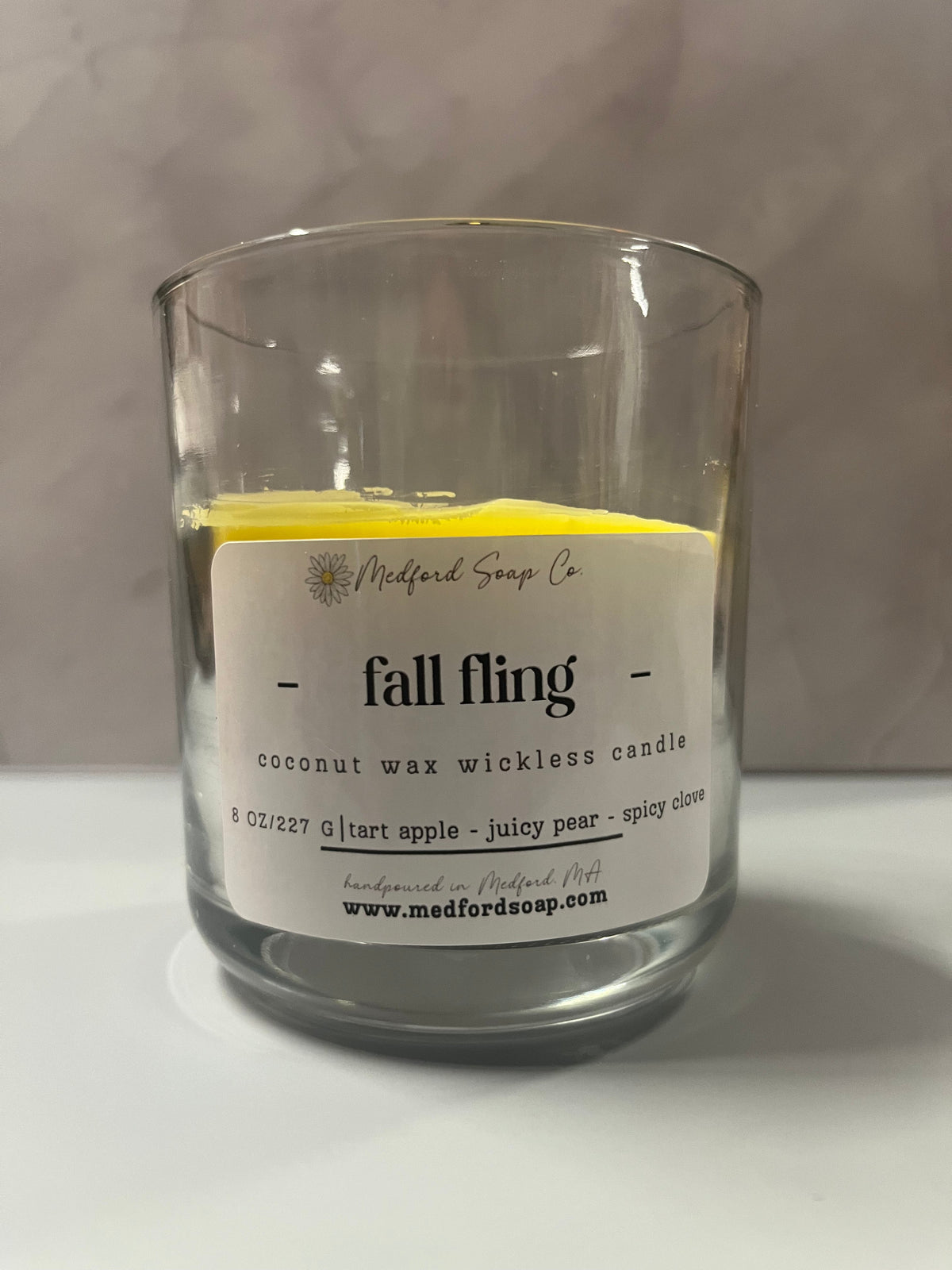Wickless candle in a clear glass jar with fall fling wax label