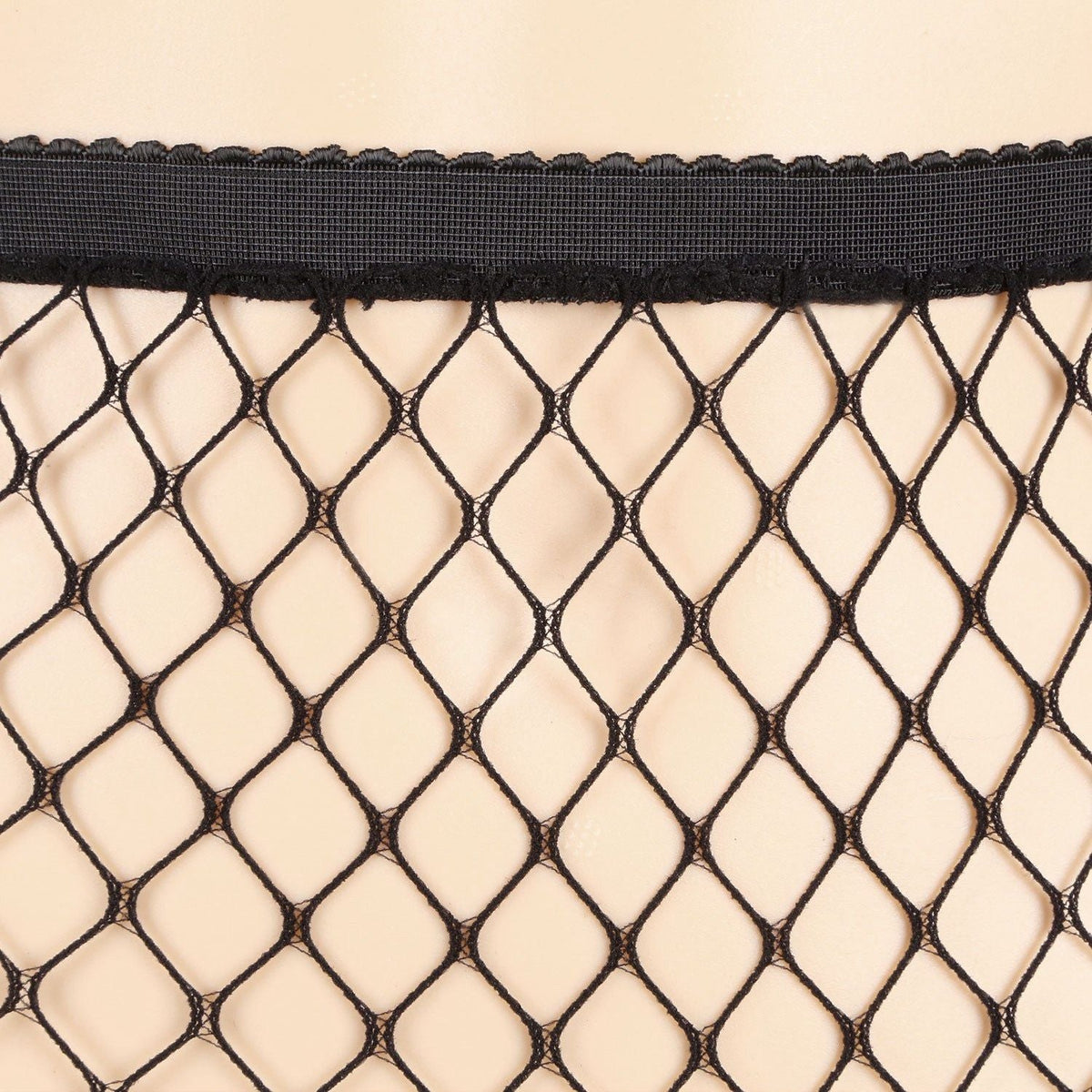Black fishnet tights with diamond mesh pattern and scalloped top edge