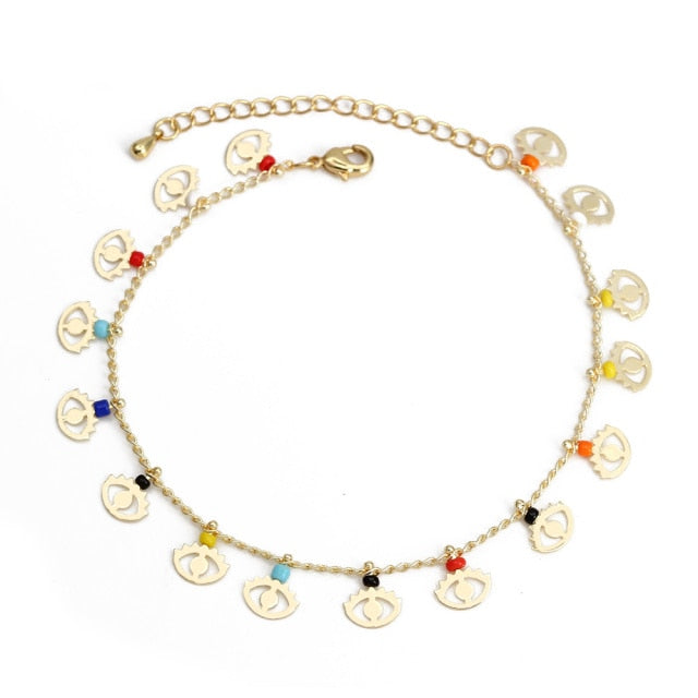 Gold charm bracelet with coin-style charms and red, blue, and turquoise bead accents