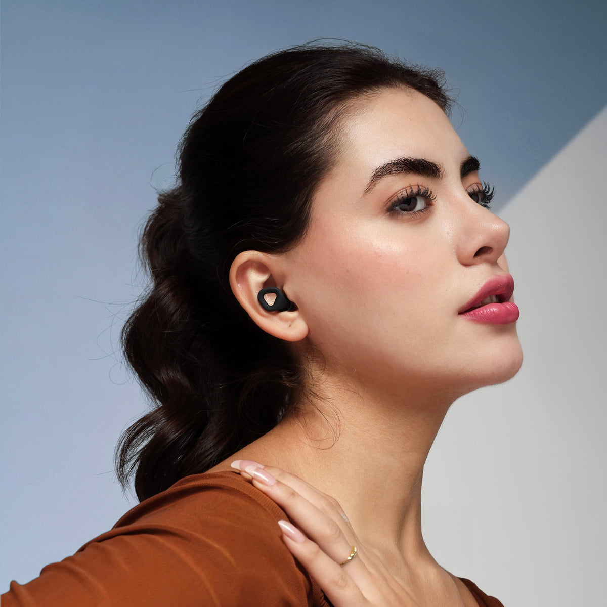 Onyx black earplugs in profile view, small curved silicone tip in ear