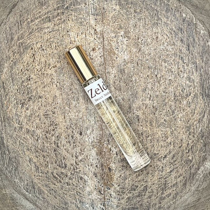 Zelda Sweet Anthem fragrance spray bottle with gold cap, shown at an angle