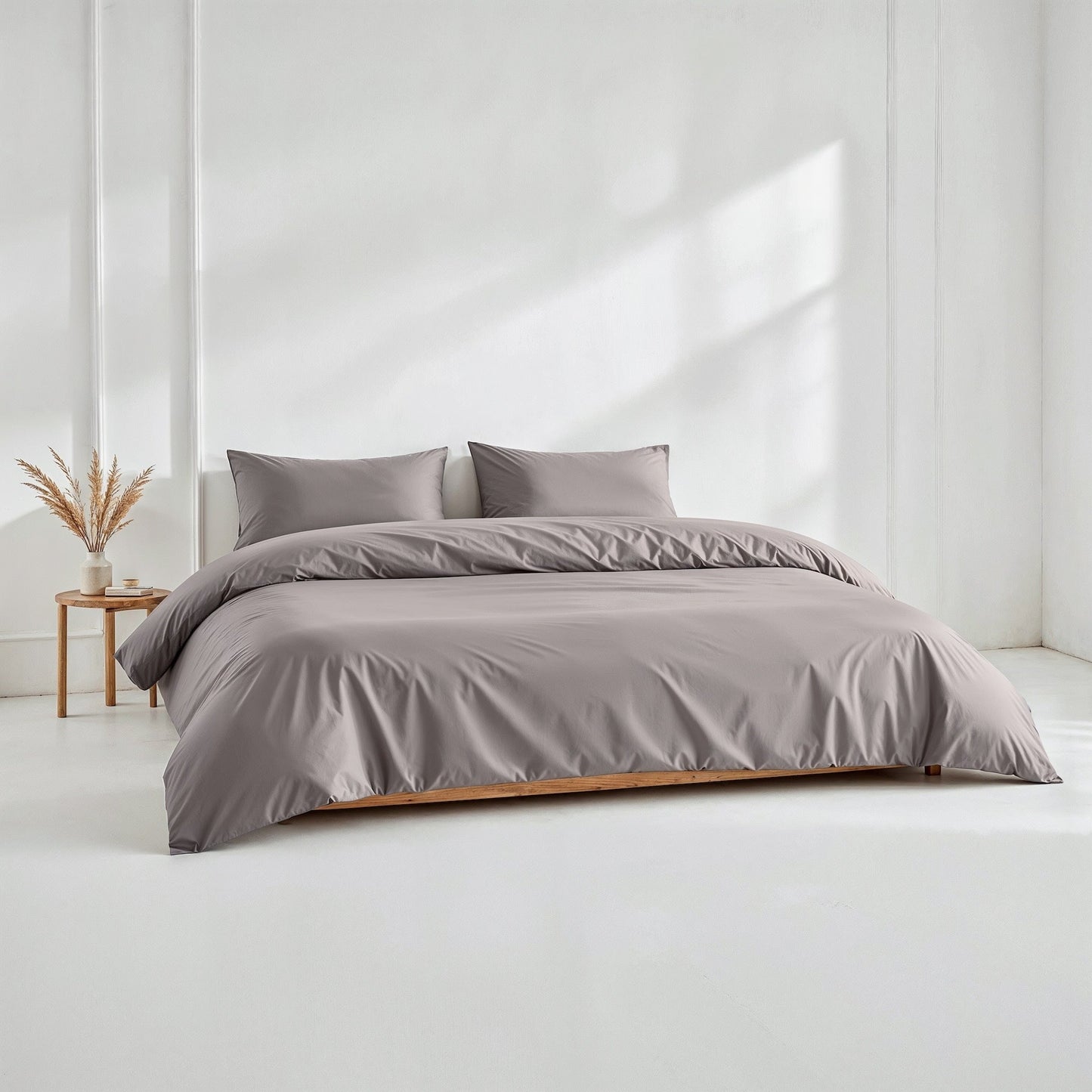 Gray sateen bedding bundle with duvet and two matching pillows on a bed