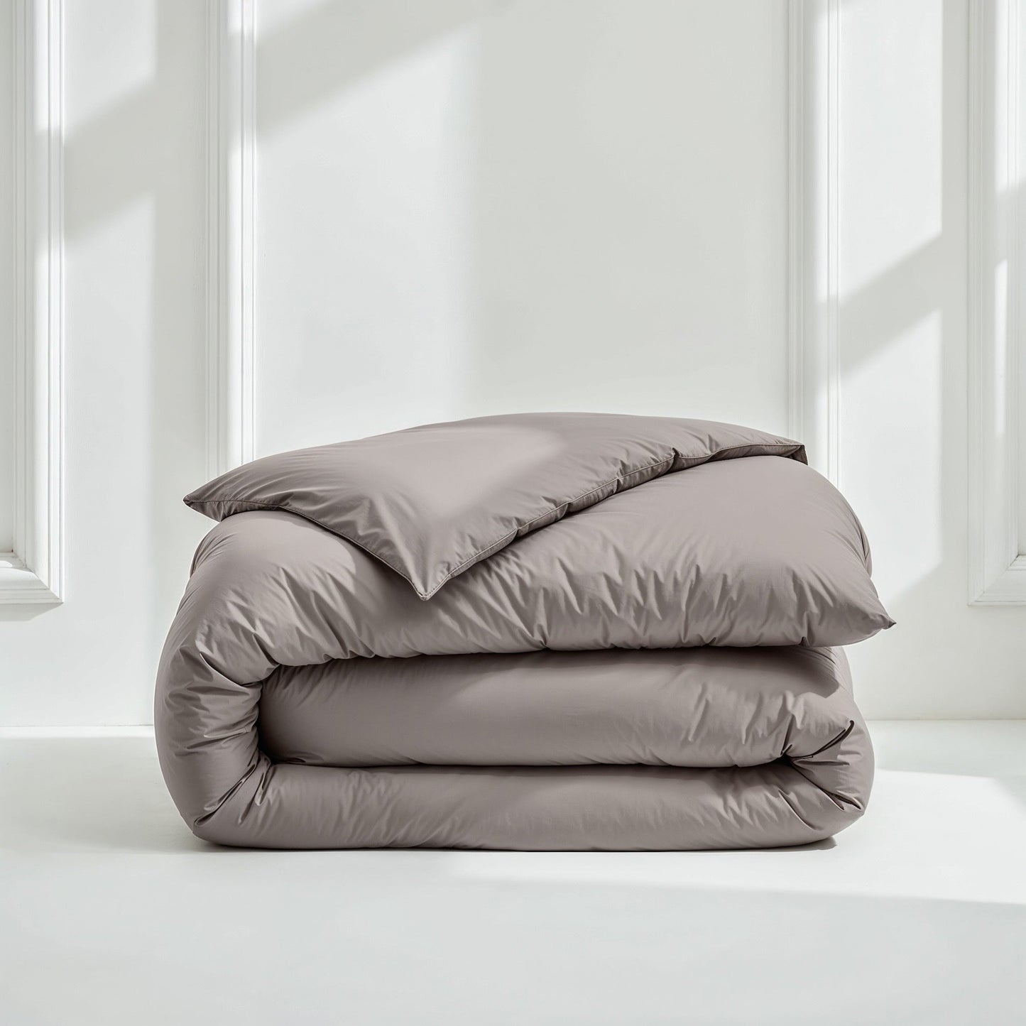 Gray sateen bedding bundle with a folded duvet and pillow on top