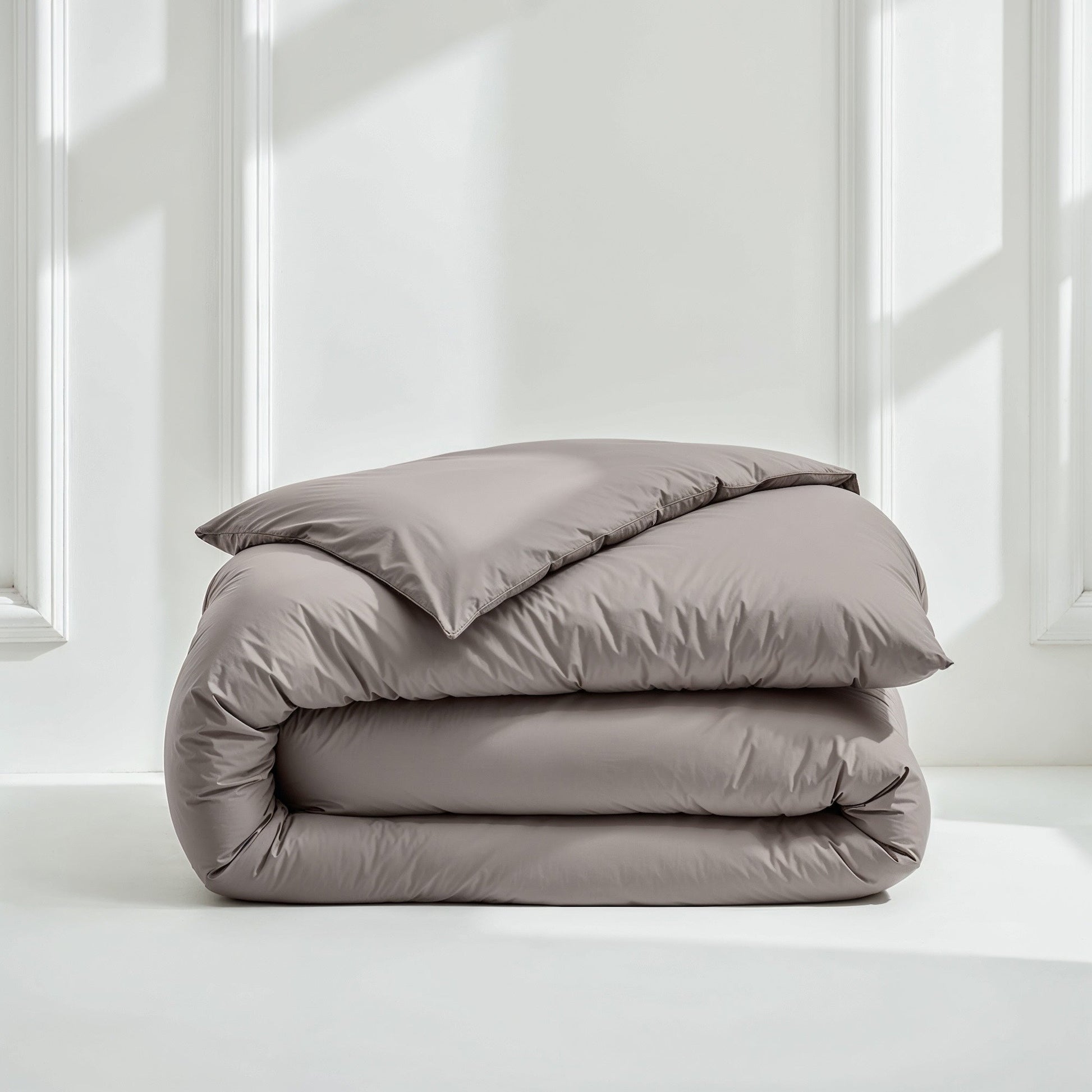 Gray sateen bedding bundle with a folded duvet and pillow on top