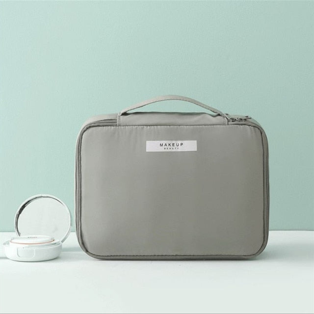 Gray cosmetic bag with top handle and side strap pocket
