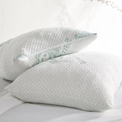 Adjustable cooling pillows set of two, white with mint geometric covers on bed