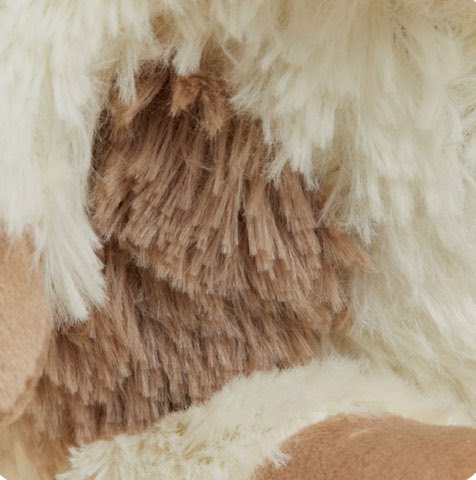Close-up of white-and-brown puppy plush fur with stitched chest panel