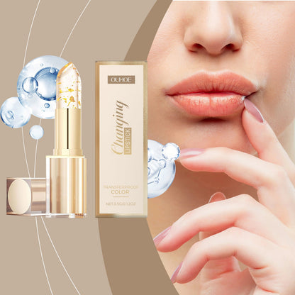 Gold color-changing nourishing lipstick; hand applies coral-pink lip color