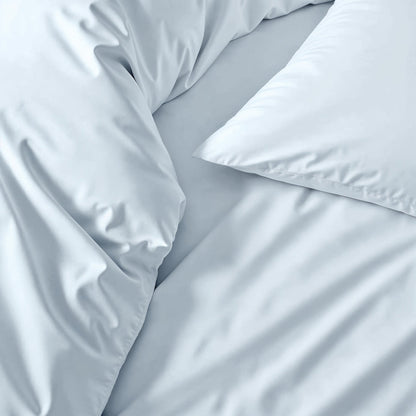 Sateen sheet set in light blue-gray, close-up of smooth bedding fabric