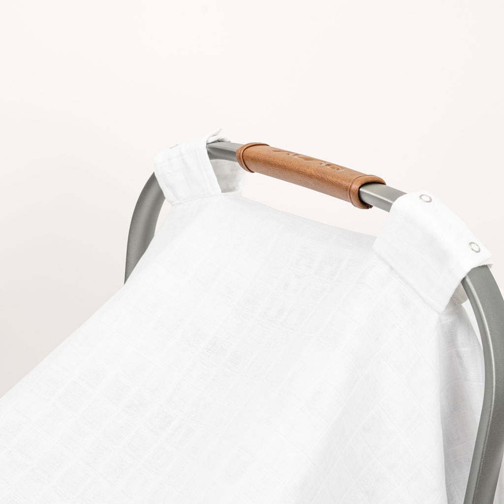 Muslin car seat cover, white fabric draped over stroller handle