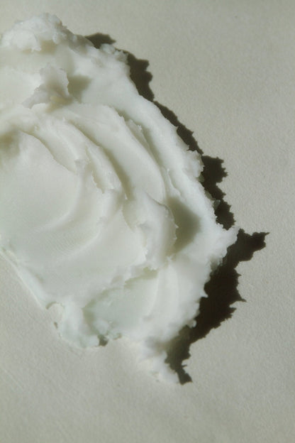 Creamy white balm texture, thick paste with smooth swirl indentation