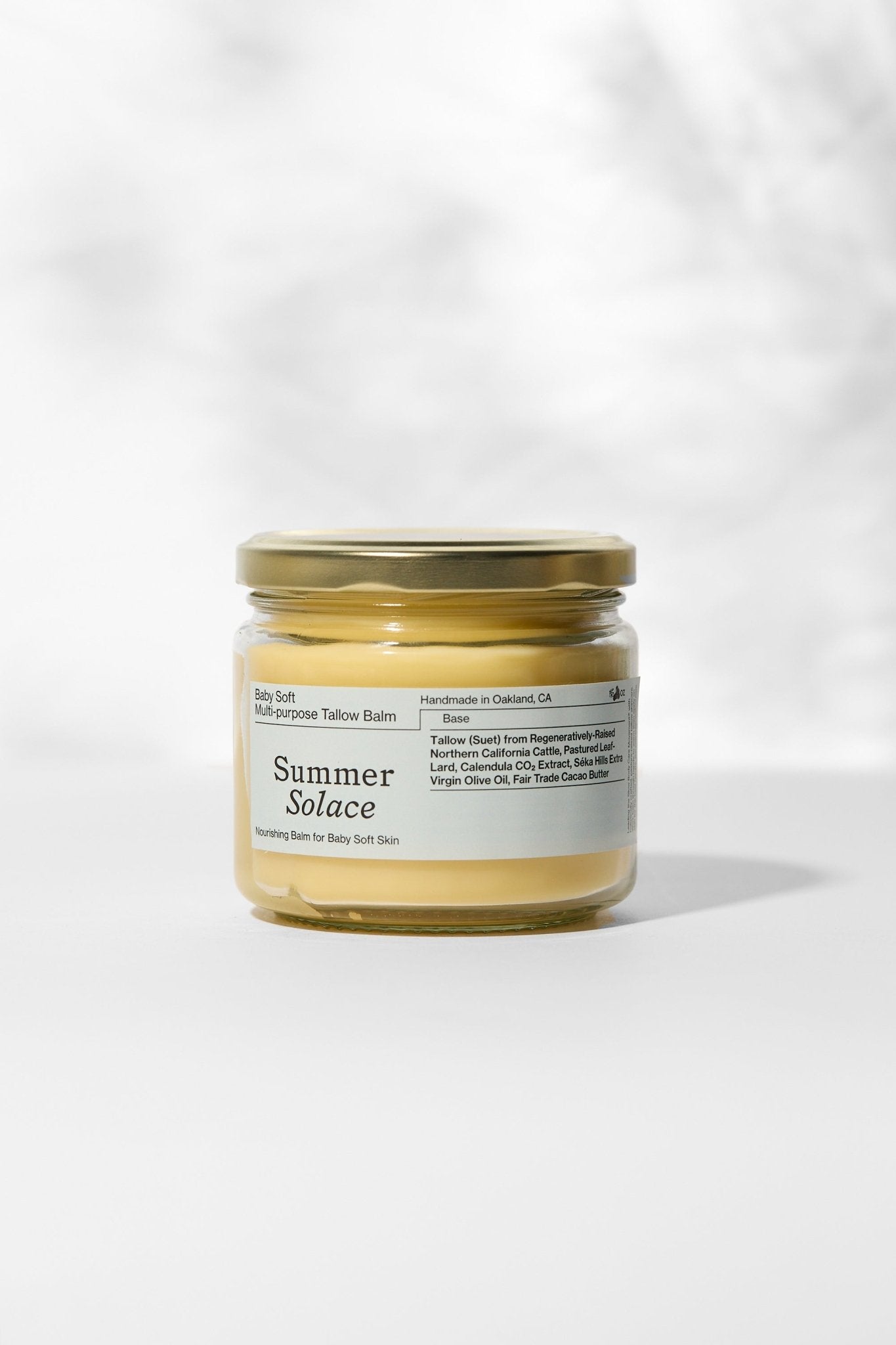 Glass balm jar with gold lid and pale yellow cream, labeled Summer Solace