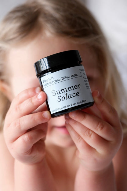 Family balm jar held in hands, label facing up, creamy balm visible