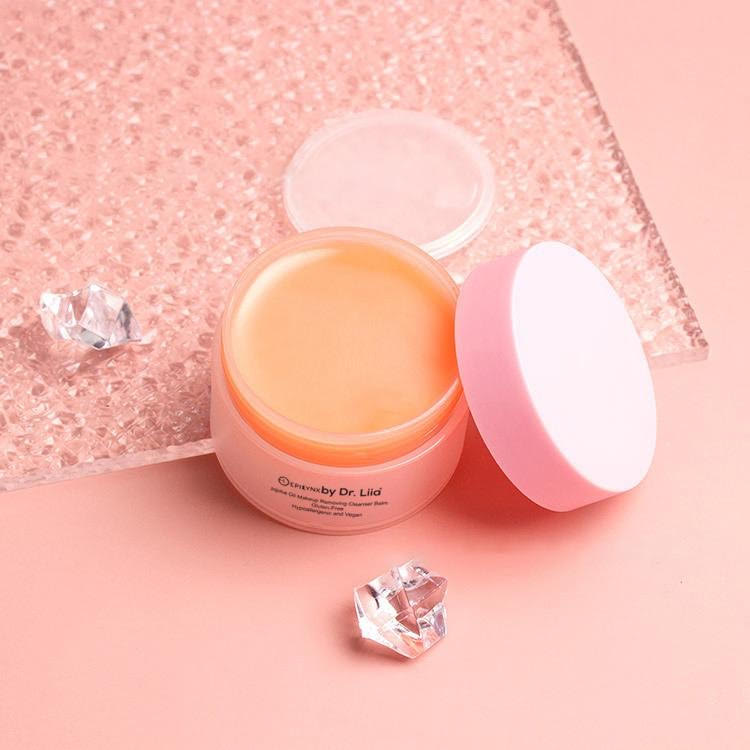 Orange makeup remover balm jar with pink lid, plus an open balm lid