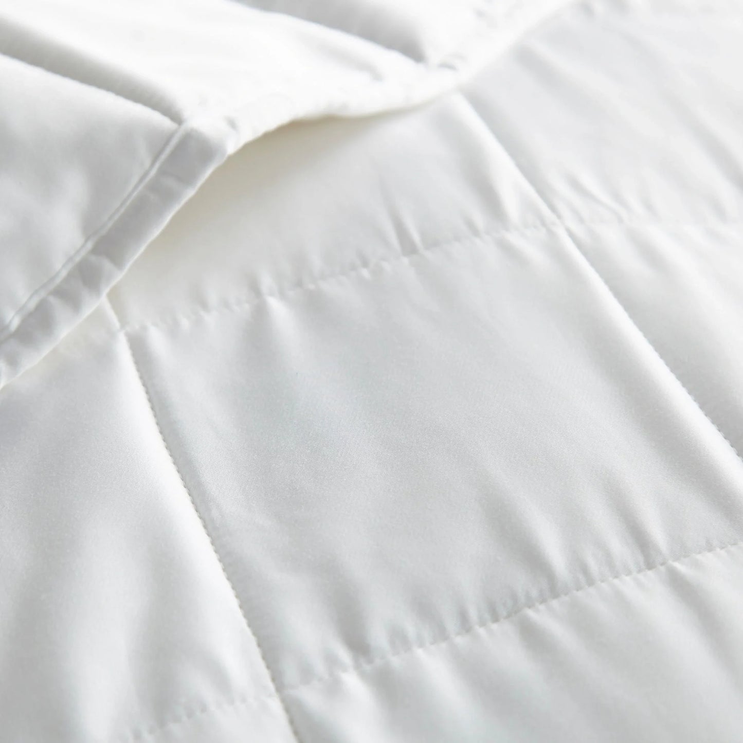 White duvet comforter close-up showing baffle stitching and seam