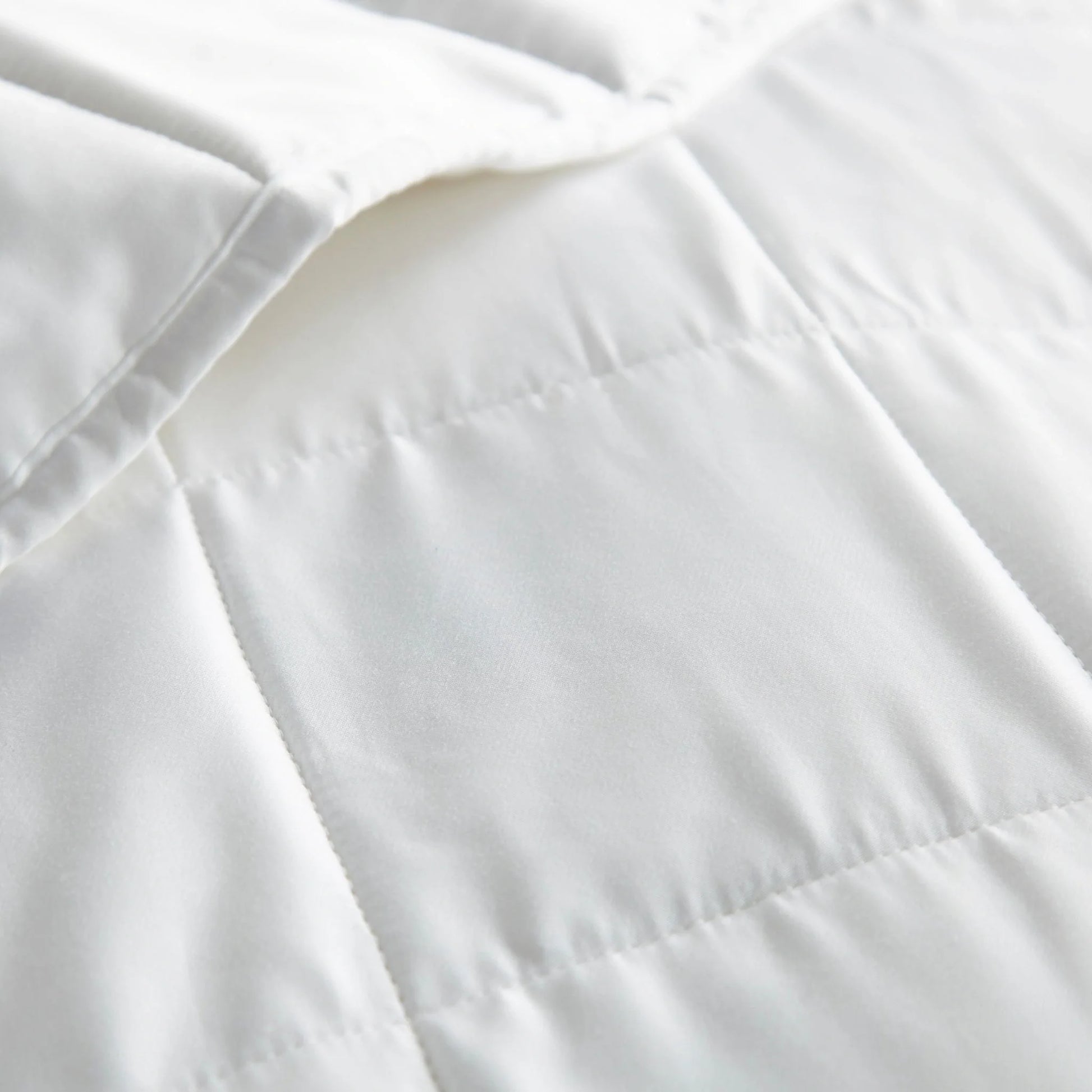 White duvet comforter close-up showing baffle stitching and seam