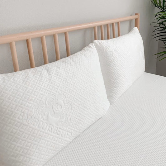 White quilted pillow cover with stitched floral emblem, square edge