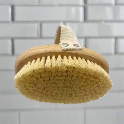 Hanging bath brush with oval tan sisal bristles and wooden handle