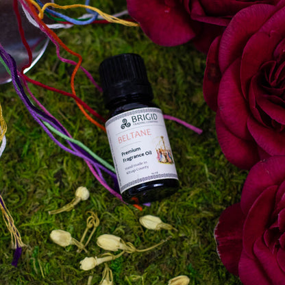 Essential oil blend bottle Beltane with black cap on grass and flowers