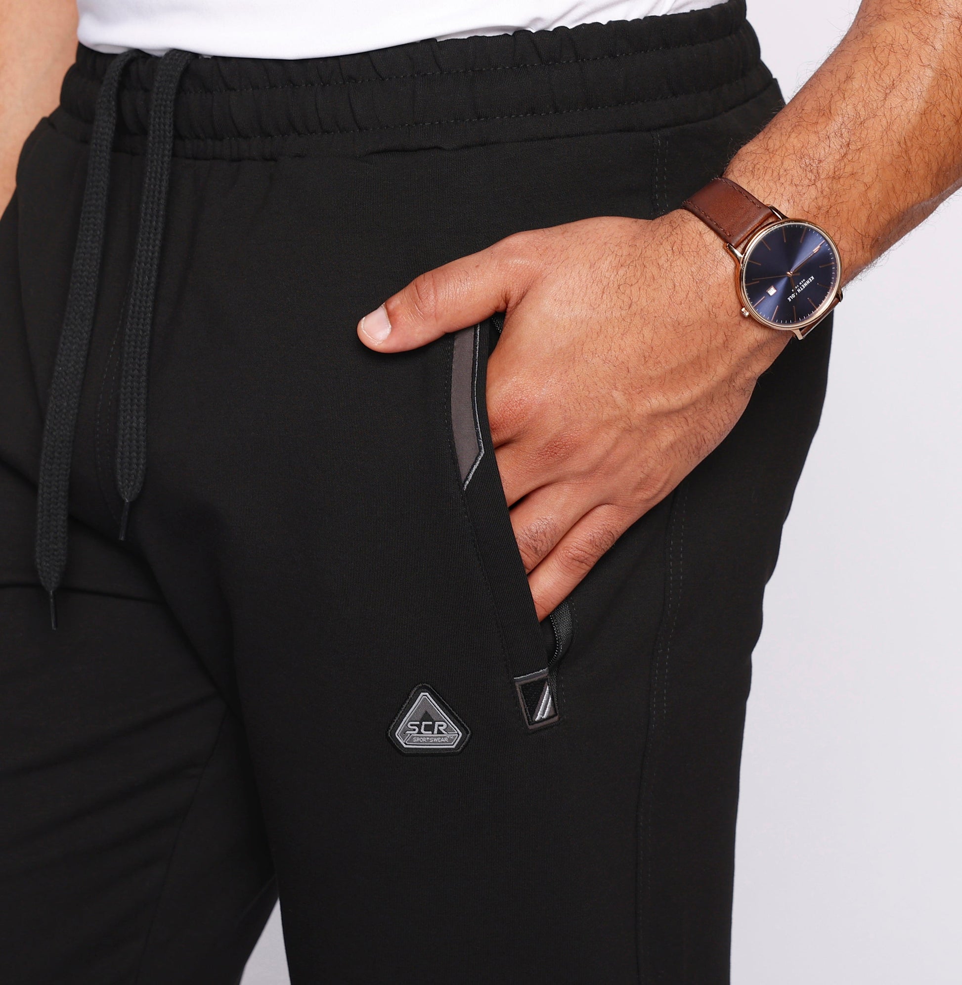 Black athletic sweatpants close-up: elastic waistband, drawstring, side pocket detail