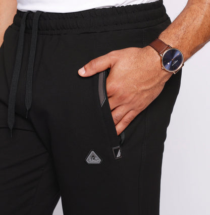 Black athletic sweatpants close-up: elastic waistband, drawstring, side pocket detail