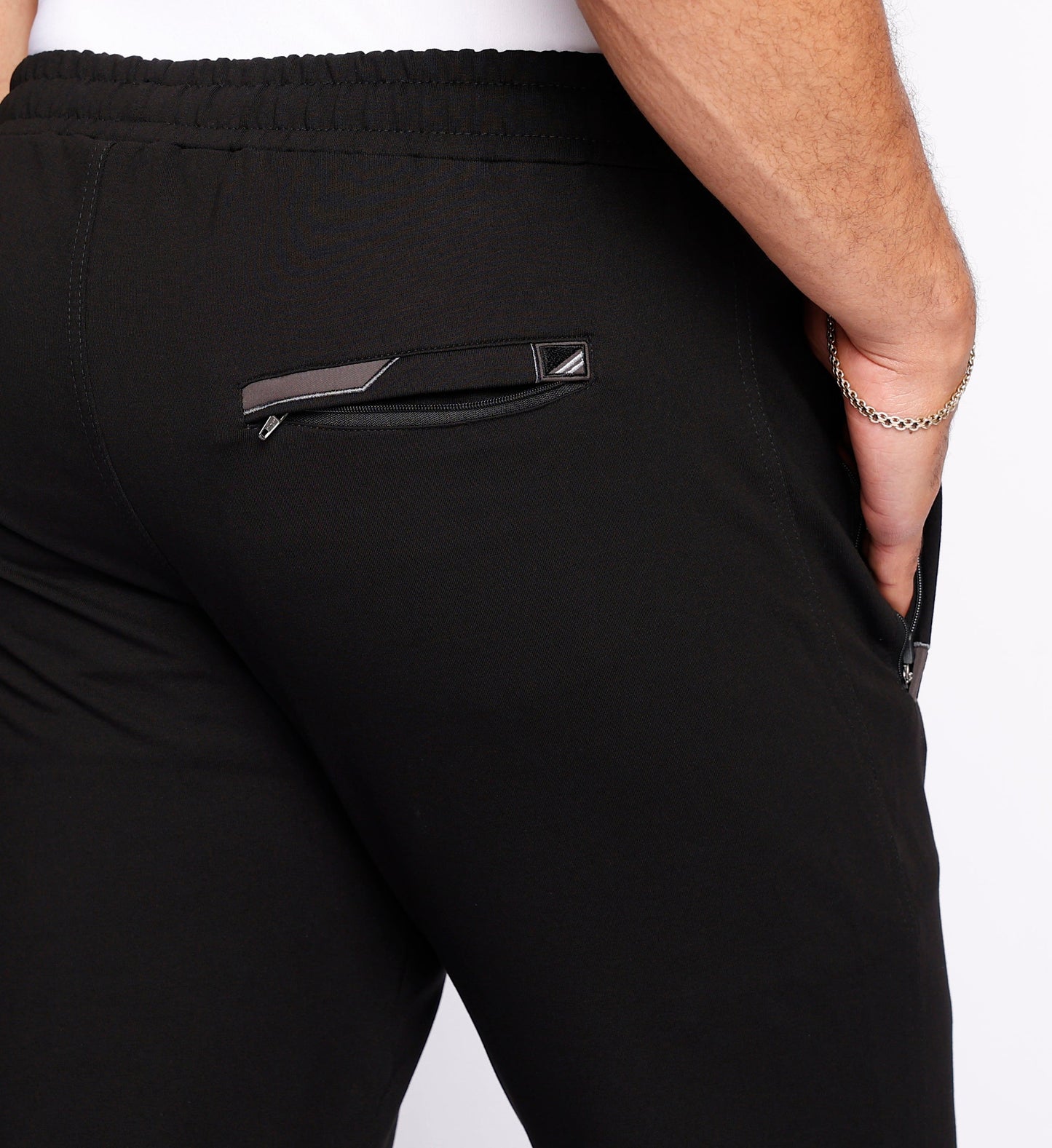 Black athletic sweatpants close-up of front pocket and logo patch