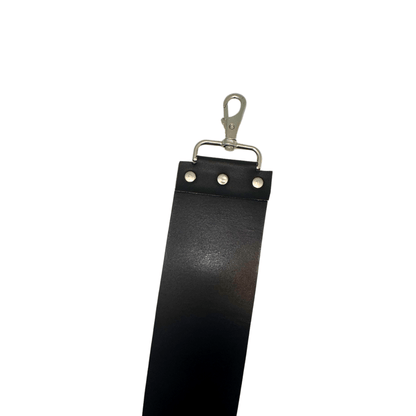 Black leather razor strop with brass clip handle and rivet row