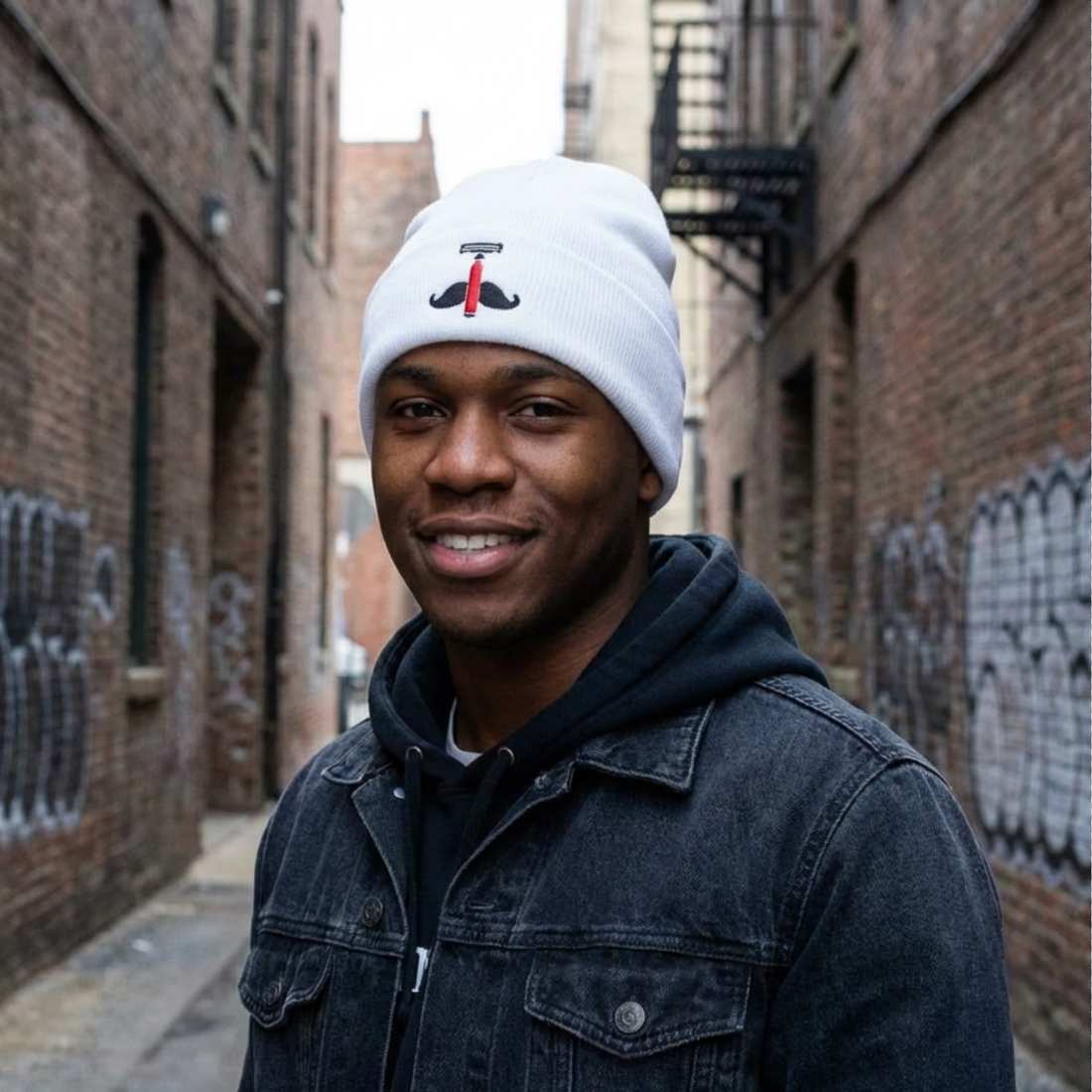 Light gray knit beanie with black anchor emblem and red accent on front.
