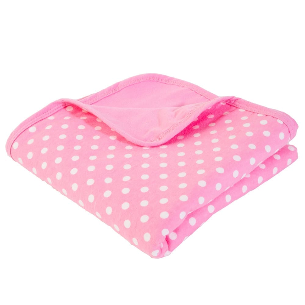 Baby blanket in pink with white polka dots, folded with padded edge
