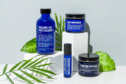 Skincare set with blue face cleanser bottle, jar, and box with plants