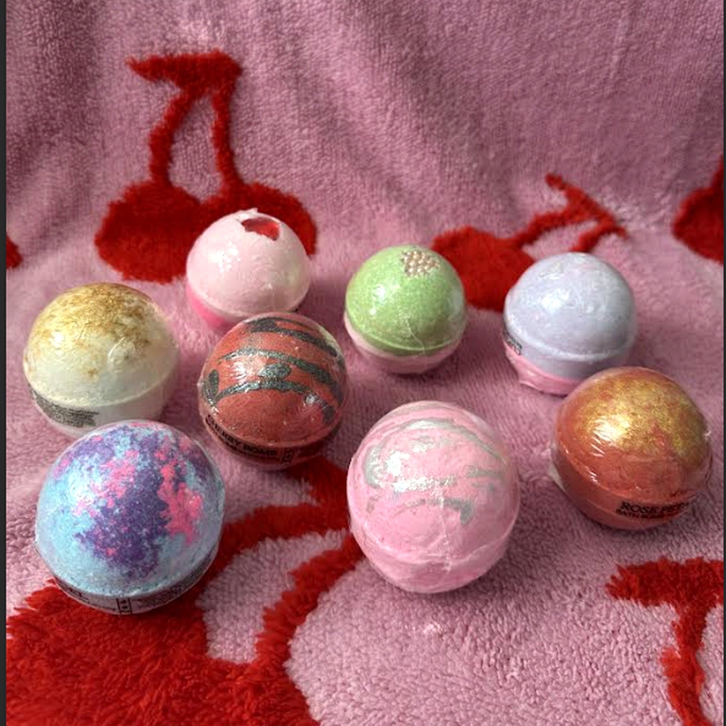 Bath bomb box with assorted spherical bath bombs in red, pink, green, and blue tones