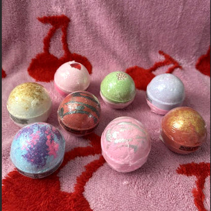 Bath bomb box with assorted spherical bath bombs in red, pink, green, and blue tones