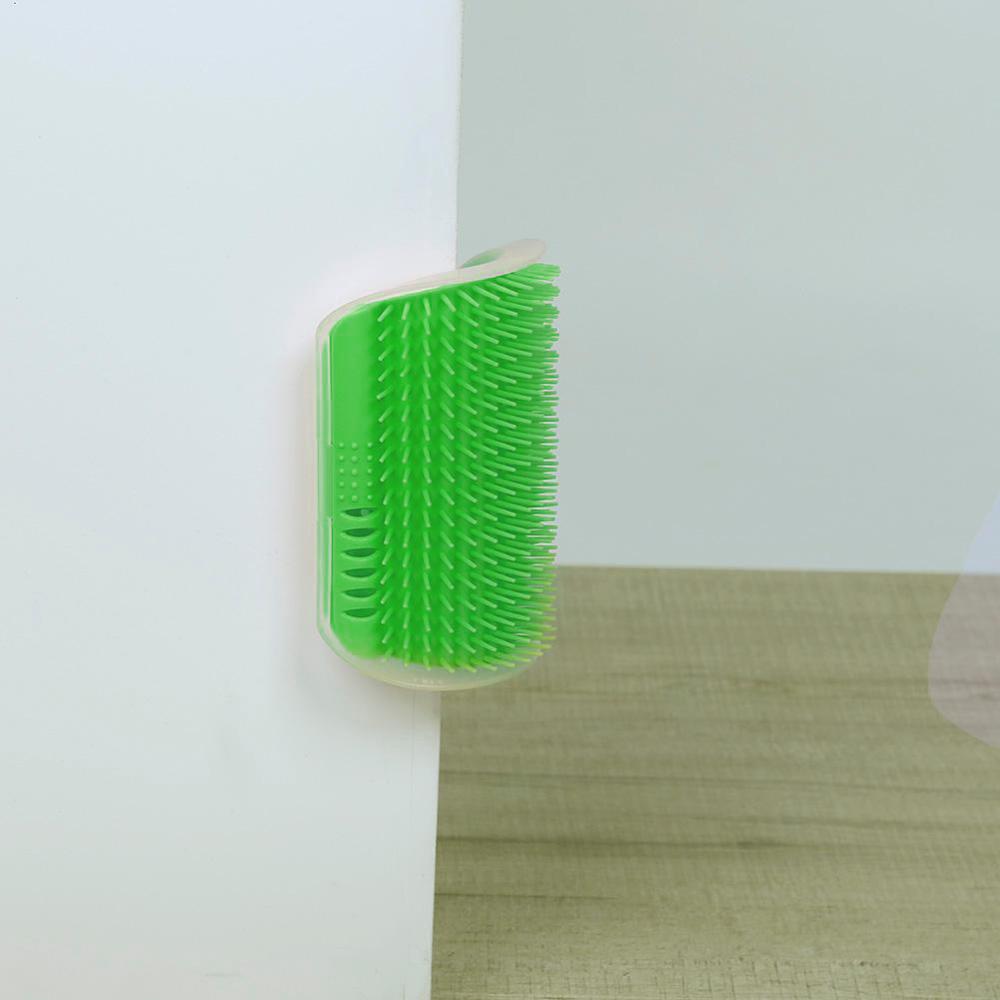 Green corner grooming brush with bristles, mounted in a wall corner.