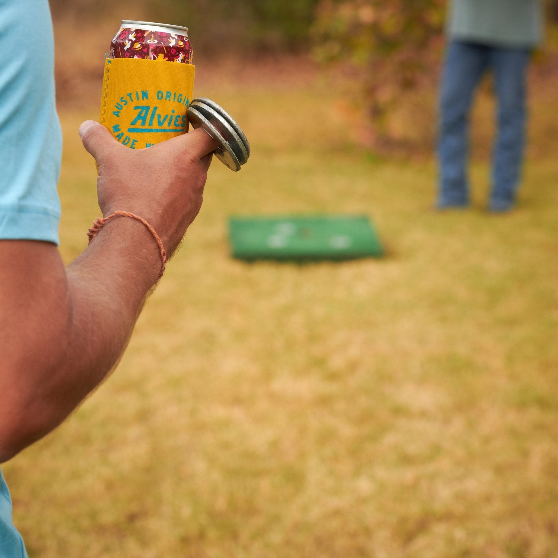 Yellow can cooler sleeve on a soda can held in hand