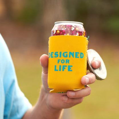 Yellow can cooler sleeve reading “DESIGNED FOR LIFE” on a soda can