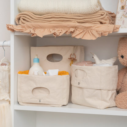 Two light-beige canvas storage baskets, each with an oval cutout handle