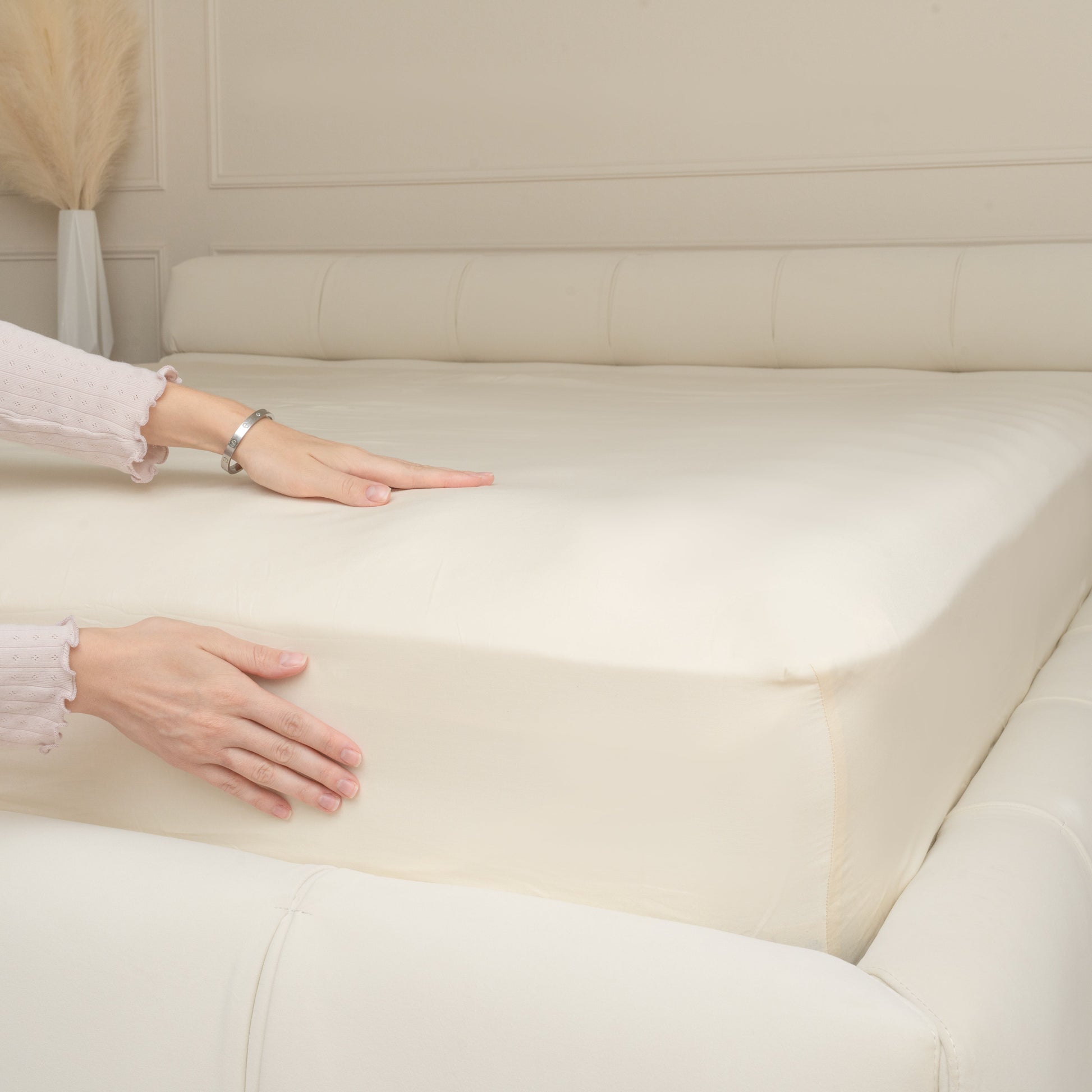 Natural cotton fitted sheet on a bed, smooth top surface with fitted corners