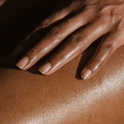 Body lotion being rubbed into skin on hands, glossy moisturized finish