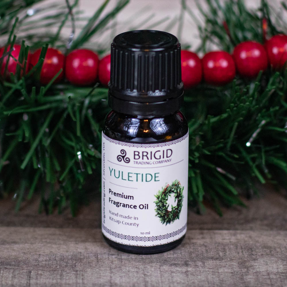BRIGID YULETIDE premium fragrance oil bottle with black cap on pine needles