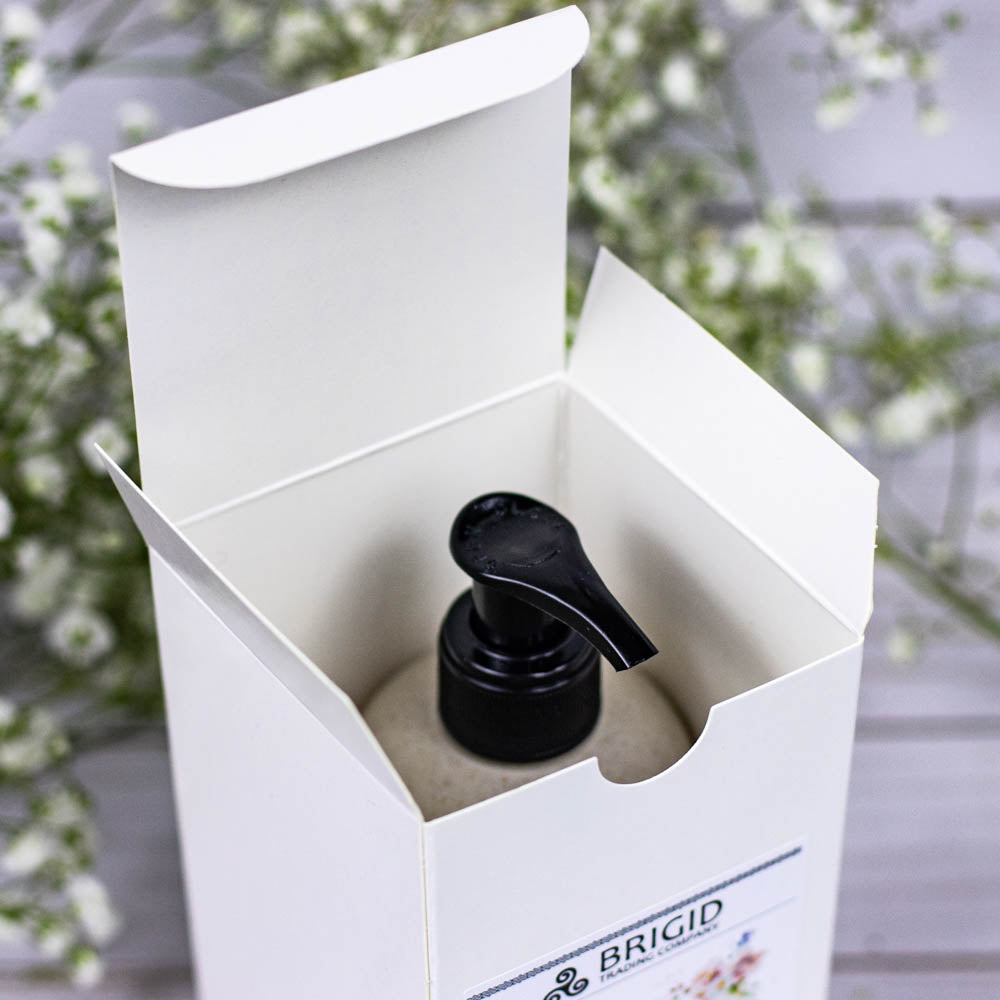 Body lotion bottle with black pump inside an open white shipping box