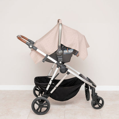 White muslin car seat cover fitted on stroller, checkered fabric canopy panels