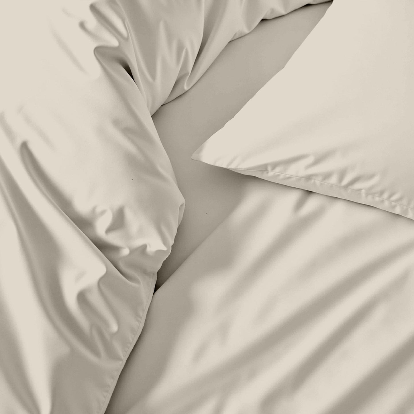 Sateen bedding bundle close-up of light beige fitted bedding folds and stitching