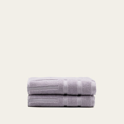 Lilac cotton bath towel, folded with terry texture and horizontal bands