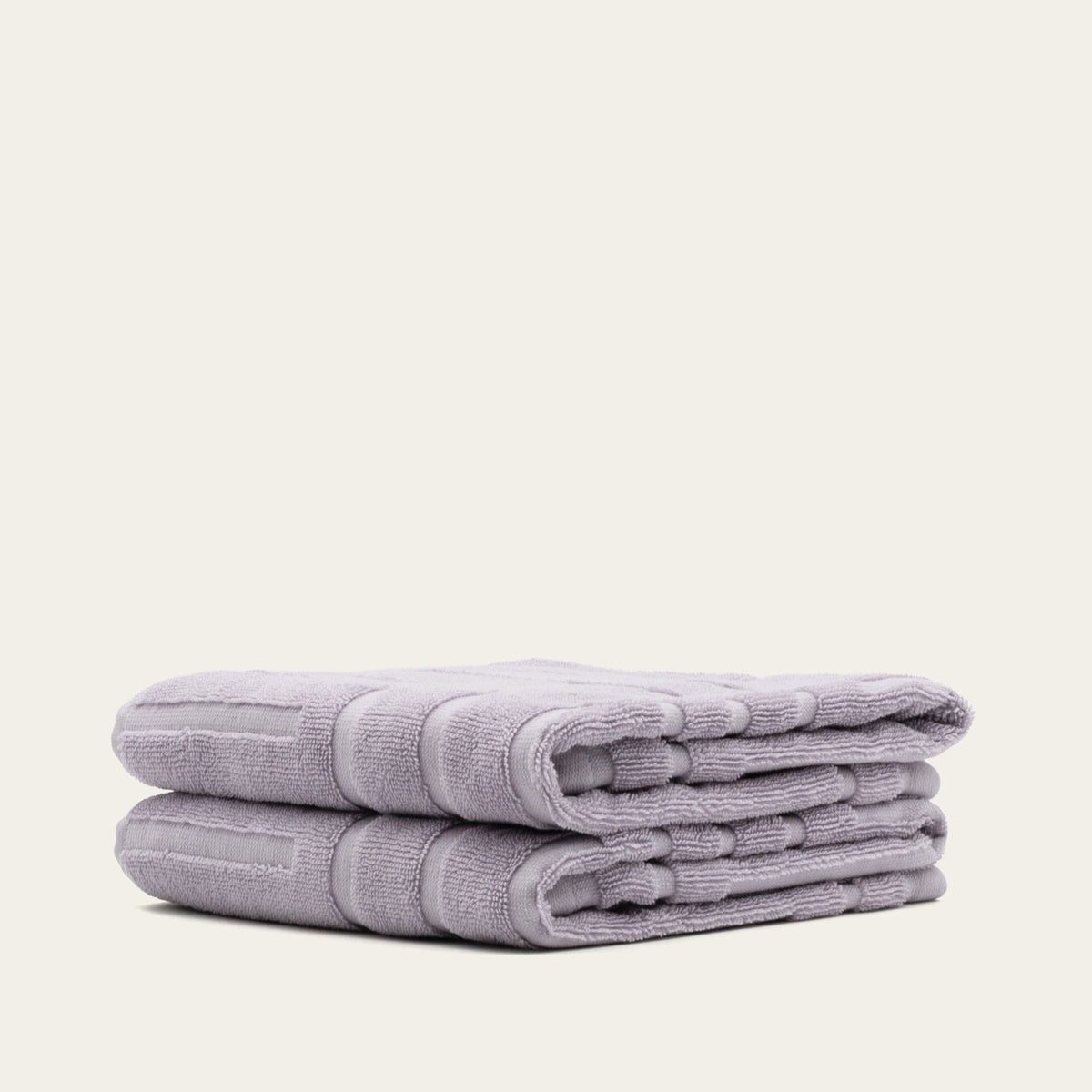 Lilac cotton towels, neatly folded stack with terry loop texture