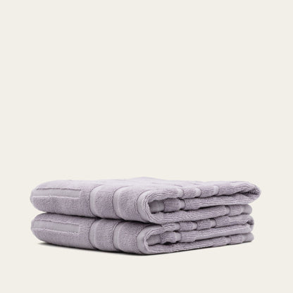 Lilac cotton towels, neatly folded stack with terry loop texture