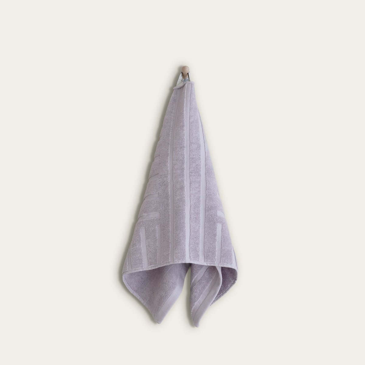 Lilac cotton towel, folded with jacquard stripe pattern and soft terry edge