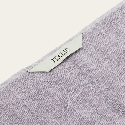 Lilac cotton towel corner with decorative trim and “ITALIC” label